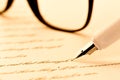 White fountain pen writing a letter, glasses Royalty Free Stock Photo