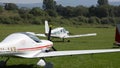 White four seat propeller-driven Zlin Z43 airplane moves on grass landing strip in small airport