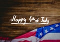 White fourth of July graphic against wood table and american flag