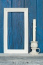 White frame and a candle on a background of blue boards