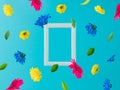 White frame with colorful flowers flying on a blue background. Positive news, thinking and energy concept. Optimistic future, mood