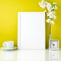 White frame, flower in vase, cup with tea or coffee, clock on wh