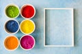 white frame with holi color powder bowl painted blue backdrop Royalty Free Stock Photo