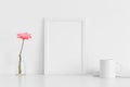 White frame mockup with a chrysanthemum in a vase, book and a mug on a white table. Portrait orientation Royalty Free Stock Photo