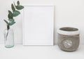 White frame mockup, eucalyptus branch in glass bottle, cement bowl, styled minimalist clean image for product marketing Royalty Free Stock Photo