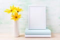 White frame mockup with golden yellow rosinweed and books Royalty Free Stock Photo