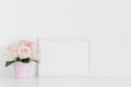 White frame mockup with pink roses in a pot on a white table.Landscape orientation Royalty Free Stock Photo