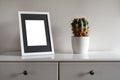 White frame mockup with plant pot on a white commode