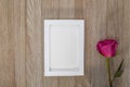 White frame mockup on rustic wooden board with pink rose Royalty Free Stock Photo