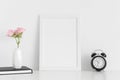 White frame mockup with workspace accessories  and pink roses in a vase on a white table.Portrait orientation Royalty Free Stock Photo