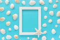 White frame with starfish on blue background and seashells. Creative Flat lay Top view Template for postcard, design Copy space Royalty Free Stock Photo