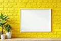 White framed canvas on textured yellow brick wall Studio shot , mockup, orange Royalty Free Stock Photo