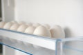 White fresh chicken eggs from fridge. Eggs on shelf of refrigerator. Storage of products at home