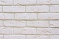 White fresh-painted surface of brickwork facade of old renovated building. White brick wall background.