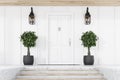 White front door of white house with trees, stairs