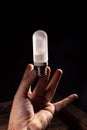 White frosted flash pilot lamp in hand. Studio photo in hard light Royalty Free Stock Photo