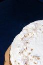 White frosting cake, partial close up, with coconut shavings with black background for text. Celebration concept