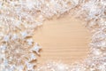 White frosty branches, covered with snow, snowflake and round copy space on natural unpainted wooden background.