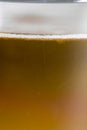 White froth on a blond beer served on a glass macro still Royalty Free Stock Photo