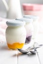 White and fruity yogurt in jar on white table