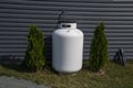 A white fuel tank next to a house