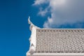 White gable apex on blue sky with cloud