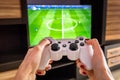 White gaming joystick, gamepad, standard controller is aimed at the TV, fifa football game ps4, xbox