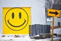 Garage with Yellow Smiley Face and a Street Sign Arrow