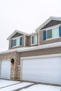 White garage doors at home exterior decorated with wreath and christmas lights Royalty Free Stock Photo