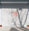 A white garage door has a number written on it in red