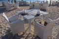 White garden furniture made of artificial rattan on the beach on the island of Gili Meno. Comfortable armchairs at set tables Royalty Free Stock Photo