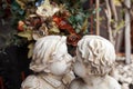 White garden sculpture of two kissing kids. Curly hair children angels kissing art statue of plaster