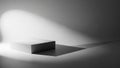 Minimalist White Cube Pedestal with Dramatic Spotlight and Long Shadow on a Gradient Gray Background Royalty Free Stock Photo