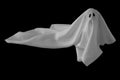 White ghost sheet costume rise up from the floor with black background. Minimal Halloween scary concept