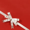 White gift bow ribbon red paper background corner diagonal Royalty Free Stock Photo