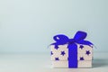 White gift box with blue star pattern and blue ribbon bow