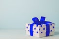 White gift box with blue star pattern and blue ribbon bow Royalty Free Stock Photo