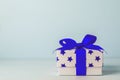 White gift box with blue star pattern and blue ribbon bow Royalty Free Stock Photo