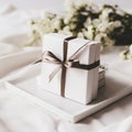 White gift box with brown bow on plate at wedding ceremony Royalty Free Stock Photo