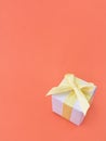 White gift box on coral color background. vertical, copy space.
