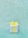 White gift box on light teal green background. Vertical. Royalty Free Stock Photo