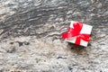 White gift box with perfect red ribbon bow on wooden table background in top view with copy space. Royalty Free Stock Photo