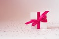 White gift box with pink satin ribbon. Minimalist greeting card with copy space Royalty Free Stock Photo