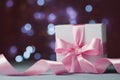 White gift box or present against magic bokeh background. Greeting card for Christmas, New Year or wedding. Royalty Free Stock Photo