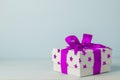 White gift box with purple star pattern and purple ribbon bow Royalty Free Stock Photo