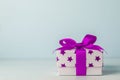 White gift box with purple star pattern and purple ribbon bow Royalty Free Stock Photo