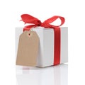 White gift box with red ribbon bow and paper tag Royalty Free Stock Photo