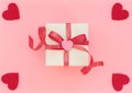 White Gift Box With Red Ribbon And Pink Heart On Pink Background With Four Red Hearts. Valentine`s Day Concept. Valentine Greetin