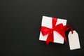 White gift box with red ribbon with sale tag isolated on black background Royalty Free Stock Photo