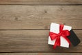 White gift box with red ribbon with sale tag isolated on grey wooden background Royalty Free Stock Photo